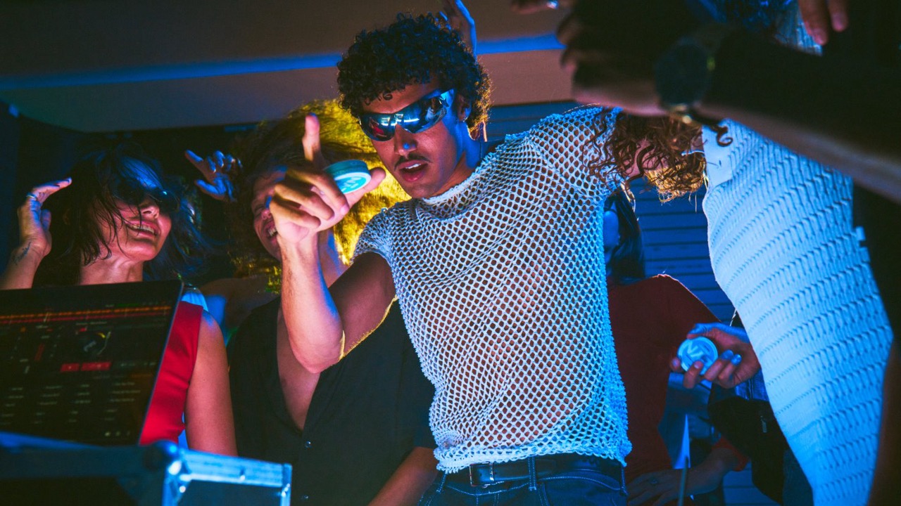 Adults dancing at a party wearing sunglasses and holding a can of ZYN Cool Mint nicotine pouches